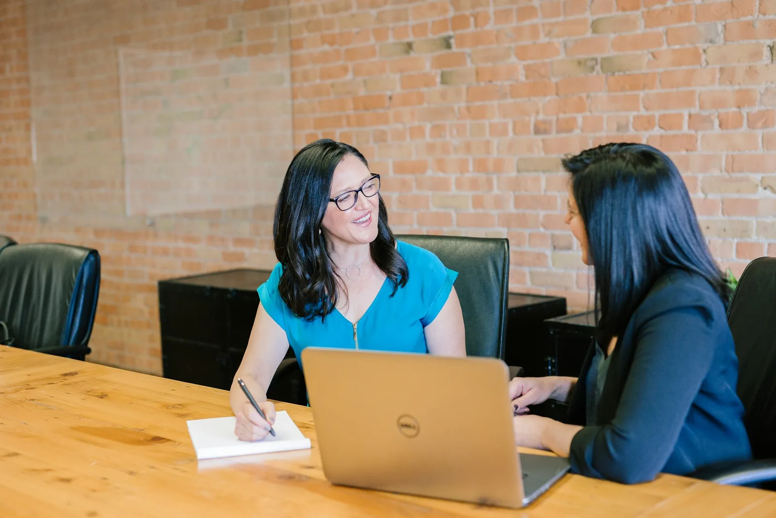 Two business professionals working together around a laptop